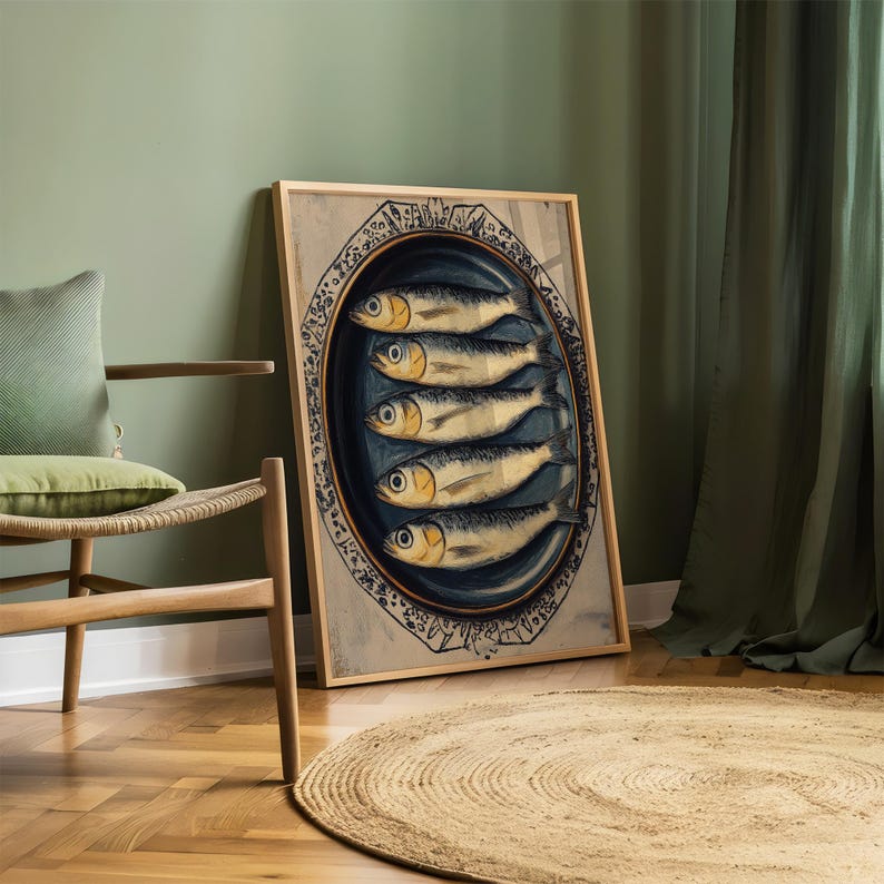 May include: A framed print of a vintage illustration of five sardines on a blue and white plate. The sardines are arranged in a row, with their tails pointing to the right. The plate is decorated with a floral pattern.