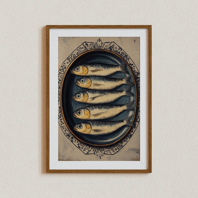 May include: A framed print of a vintage illustration of six silver fish arranged on a blue and white oval plate. The fish are arranged in a row, with their heads facing the viewer. The plate is decorated with a floral pattern.