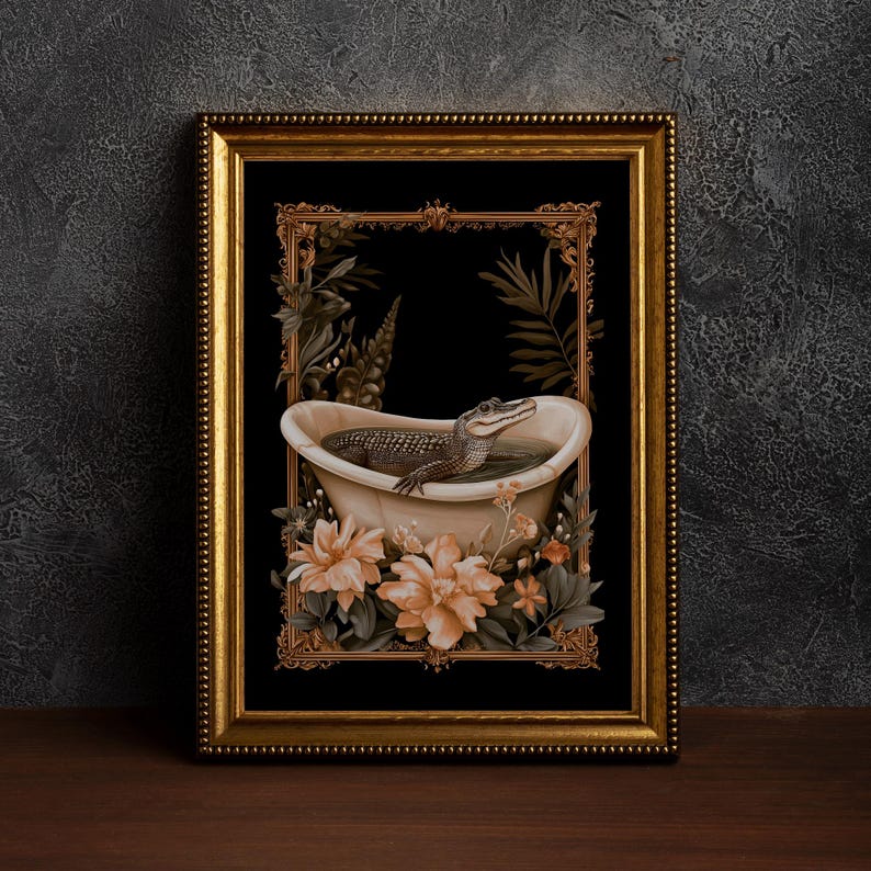 May include: A framed art print depicting an alligator in a bathtub. The artwork is set against a black background and framed with a gold ornate frame. Peach-coloured flowers and green foliage surround the tub.