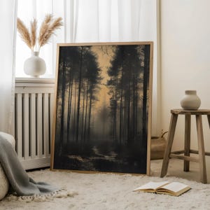 May include: A framed print of a misty forest scene with tall trees and a path leading into the distance. The print has a warm, golden hue and is framed in a simple wooden frame.