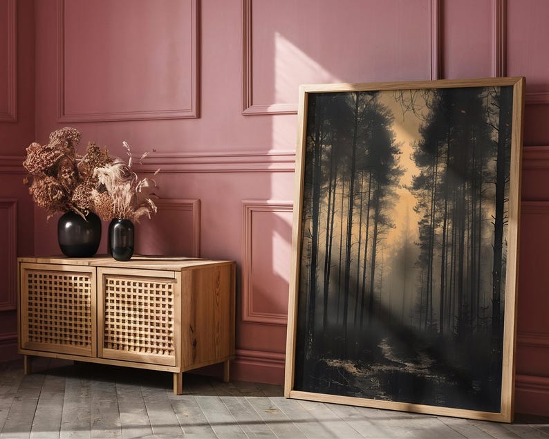 May include: A wooden cabinet with two doors and a woven rattan design. The cabinet is in front of a pink wall with white trim. A large framed print of a forest scene hangs on the wall.
