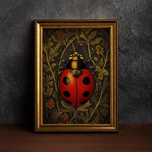 Op de afbeelding: Een ingelijste illustratie van een rode lieveheersbeestje met zwarte stippen op een donkergroene achtergrond met gouden accenten. Het lieveheersbeestje wordt omringd door gestileerde bladeren en bloemen.