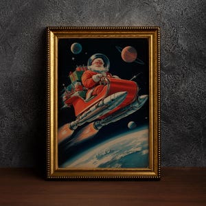 May include: A framed vintage print depicts Santa Claus in a spacesuit piloting a rocket-powered sleigh through space. The artwork features a red sleigh, planets, and a gold frame, evoking a retro sci-fi Christmas theme.