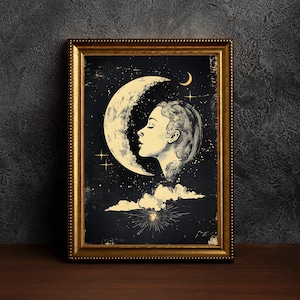 May include: Framed art print featuring a celestial design. The artwork depicts a woman's profile against a backdrop of a crescent moon, stars, and clouds. The color palette includes gold, black, and cream tones. The frame is gold.