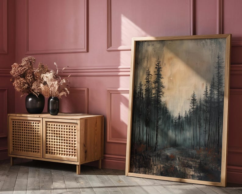 May include: A wooden cabinet with two doors featuring a woven lattice design. The cabinet is in front of a pink wall with a framed painting of a forest scene. The painting features a dark, moody forest with tall trees and a hazy sky.