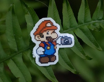 Roligt klistermärke Super Mario som håller en kamera Pixelerat miniklistermärke Present till Nintendo-älskare klistermärke för laptop och vattenflaska