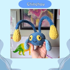 May include: A handmade blue and yellow Chinchou plush toy. The plush has two long, curved antennae with yellow tips and yellow accents on the body. The eyes are yellow with black cross-shaped pupils. The text "Chinchou" is in a blue oval.
