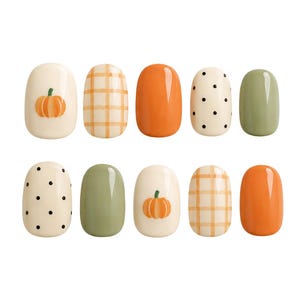 May include: A set of ten press-on nails featuring a variety of designs including solid orange, solid sage green, cream with black polka dots, cream with orange plaid patterns, and cream with small orange pumpkin illustrations on a glossy finish.