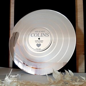 May include: A silver vinyl record with a personalised label. The label reads "MR & MRS COLINS" with the song "You Send Me" by Aretha Franklin and the date "25.06.2006".