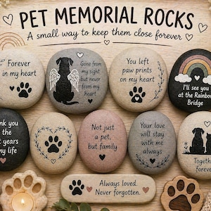 May include: A collection of memorial rocks with pet-themed designs. Each rock features a unique message, paw prints, or pet silhouettes. The rocks are in various colors and shapes, perfect for remembering beloved pets.