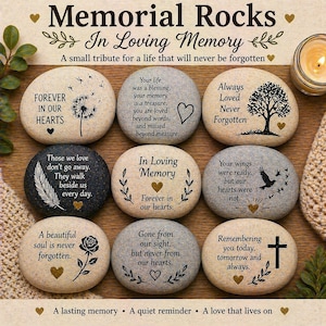 May include: A collection of memorial rocks with various inscriptions, including "Forever in our hearts" and "In Loving Memory." Each stone features a unique design, such as a tree, a feather, or a cross, and is intended as a tribute.