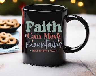 May include: Black ceramic coffee mug with the text "Faith Can Move Mountains" and "Matthew 17:20" in a colourful font.