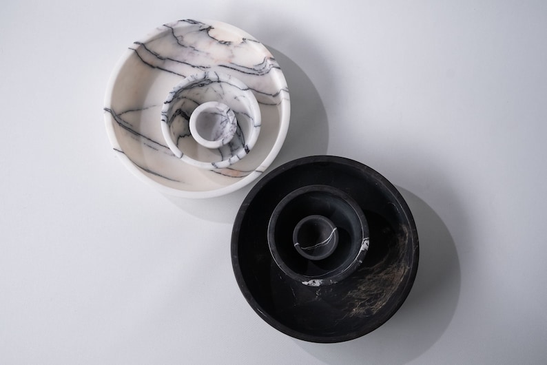 May include: Two sets of nesting bowls, one set is white with black marbling and the other set is black with white marbling.