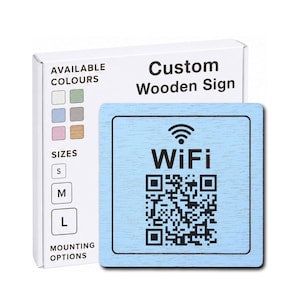 Può includere: Un cartello quadrato in legno azzurro con un simbolo WiFi nero, il testo "WiFi" e un codice QR. Dietro, una scatola bianca mostra "Custom Wooden Sign" con tabelle per colori, taglie S, M, L e opzioni di montaggio.