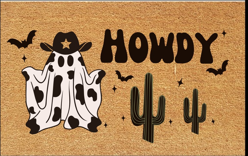 Pu&ograve; includere: Un zerbino rettangolare con sfondo beige presenta un fantasma con cappello da cowboy con una stella e un motivo a mucca. La parola "HOWDY" &egrave; in grandi lettere marrone scuro, con pipistrelli, cactus e stelle.