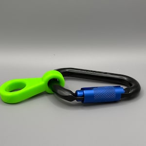 May include: A black carabiner with a blue metal gate and a bright green plastic loop. The carabiner is a safety device used for climbing and other outdoor activities.