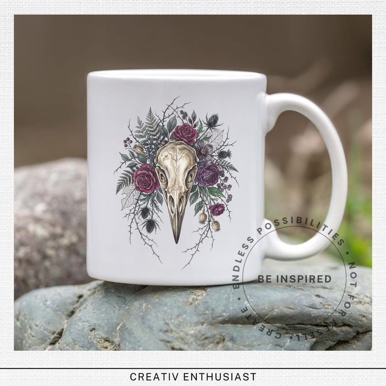 White mug with crow skull and floral design, "Be Inspired" text.