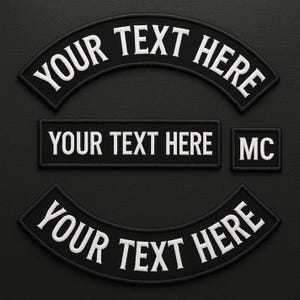 May include: A set of black embroidered patches with white text reading "YOUR TEXT HERE" in curved and rectangular shapes, plus a small square patch with "MC". These patches are designed for customisation.
