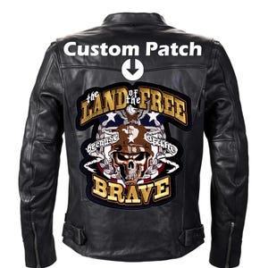May include: Black leather motorcycle jacket with a large embroidered patch on the back. The patch features a skull wearing a helmet, an American flag, and the text "The Land of the Free Because of the Brave".