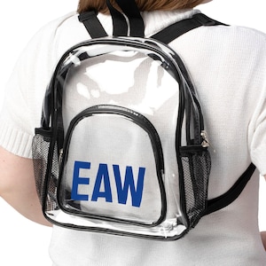 May include: Clear backpack with black trim, mesh side pockets, and adjustable straps. The backpack features the blue letters "EAW" on the front. The bag is worn on the back.