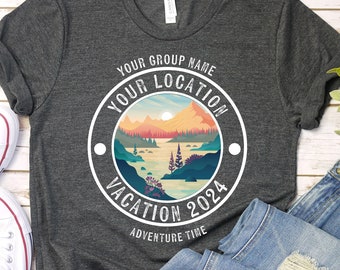 May include: A dark gray t-shirt with a white circle graphic featuring a mountain landscape and the text "Your Group Name Your Location Vacation 2024 Adventure Time".