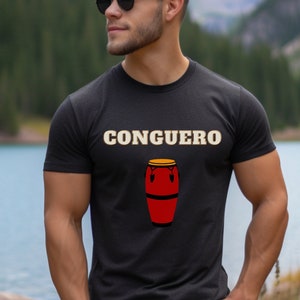 May include: A black t-shirt with the word "CONGUERO" printed in white and a red conga drum with a yellow top printed below it.