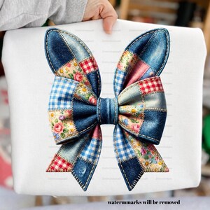 May include: A white square featuring a large denim patchwork bow design. The bow incorporates denim, floral, and gingham patterns in blue, pink, red, and white. The bow is held by a person's hand.