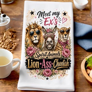 Könnte beinhalten: Ein weißes Küchentuch mit einer grafischen Illustration eines Löwen mit Krone und Sonnenbrille, eines Esels mit herzförmiger Brille und eines Geparden mit Sonnenbrille. Der Text lautet Meet my Ex's Spirit Animals Lion Ass Cheetah.