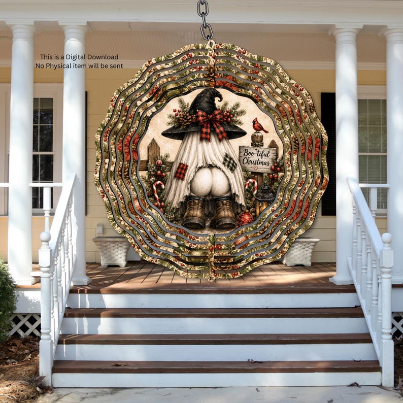 May include: A circular wind spinner featuring a gnome wearing a witch hat and boots, with a white sheet draped over its body. The design includes a sign reading Boo-tiful Christmas, red berries, pine branches, and a cardinal bird on a fence.