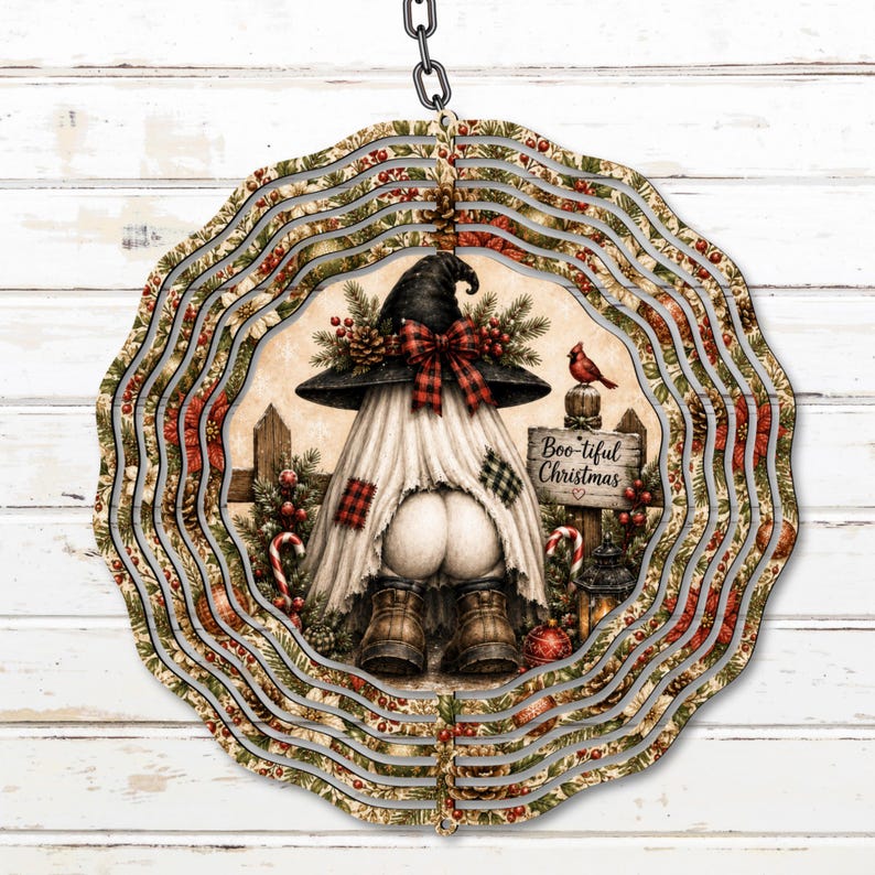 May include: A circular metal wind spinner featuring a gnome wearing a black hat with a red plaid bow, white fabric, and brown boots. The design includes holly, pine branches, a red cardinal, and a wooden sign that reads Boo-tiful Christmas.