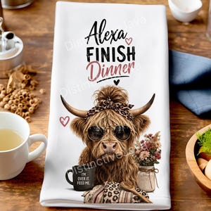 Op de afbeelding: Een witte theedoek met een afbeelding van een Schotse hooglander met een zonnebril en een luipaardprint hoofdband. De tekst luidt Alexa FINISH Dinner en I'M OVER IT. FEED ME. Het ontwerp bevat kleine hartjes en een pot met droogbloemen.