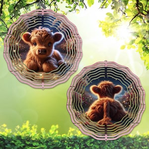 May include: Two decorative wind spinners featuring a fluffy brown Highland calf. The calf is centered within a layered, circular frame with a pink and wood-grain design. The background of the calf image has a starry night sky.
