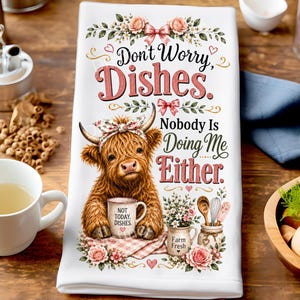 May include: White kitchen towel with a humorous design. It features a brown Highland cow wearing a floral headband and holding a mug that says "NOT TODAY, DISHES." The towel has the text "Don't Worry, Dishes. Nobody Is Doing Me Either."