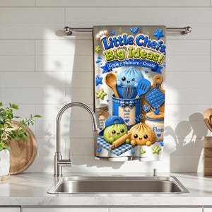 May include: A kitchen towel with the text "Little Chef's Big Ideas!" features cartoon illustrations of cooking tools and food items. The towel is predominantly blue and white, with images of a dumpling, a chef hat, and a rolling pin.