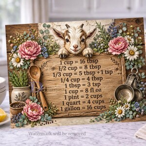 Op de afbeelding: Een rechthoekig houten bord met een illustratie van een geit bovenaan en een tabel voor keukenmaten in zwarte tekst. Het bord is versierd met roze pioenrozen, witte madeliefjes, blauwe bloemen en groen gebladerte.