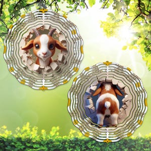 May include: Two decorative goat ornaments. Each ornament features a 3D goat design breaking through a wall. The goats are brown and white with large eyes. The ornaments have a layered, circular design with yellow accents and are hanging from a silver chain.