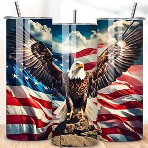 May include: A stainless steel tumbler with a design of a bald eagle with its wings spread wide against a backdrop of an American flag. The eagle is perched on a rock with a blue sky and white clouds in the background.