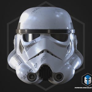 May include: A white Stormtrooper helmet with black detailing, showing a detailed design. The helmet has a weathered look and includes the text "GALACTIC ARMORY" and "PATREON.COM/GALACTICARMORY".