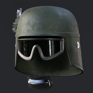 May include: An olive drab helmet with a visor and a silver-colored attachment on top. The helmet has a curved visor with a silver frame. A dark, curved piece is below the helmet.