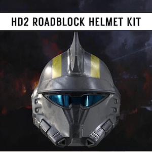 May include: A metallic gray HD2 Roadblock helmet kit with yellow stripes and blue visor lenses. The helmet has a futuristic design with detailed paneling and the text "HD2 ROADBLOCK HELMET KIT" at the top.