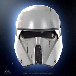 May include: A weathered white and silver helmet with a black visor and accents. The helmet has a rounded top and a detailed front panel with a circular design. The image includes the text "PATREON.COM/PEWPEWCRAFTS".