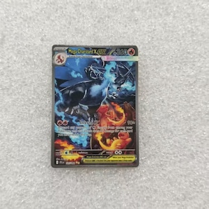 May include: A Mega Charizard X EX trading card featuring a dark blue and black dragon-like creature surrounded by blue flames and orange fire. The card displays the text Mega Charizard X EX, 360 HP, Inferno X, and various game statistics.