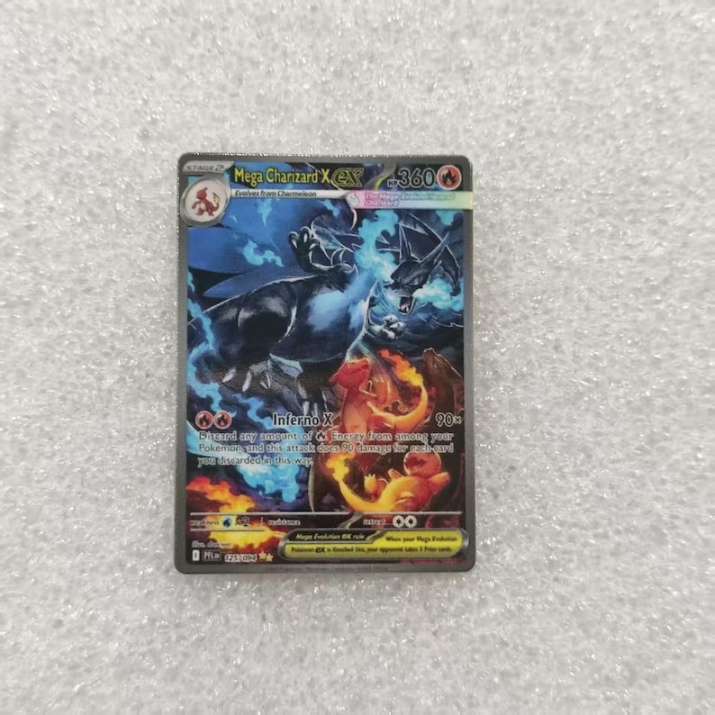 May include: A Mega Charizard X EX trading card featuring a dark blue and black dragon-like creature surrounded by blue flames and orange fire. The card displays the text Mega Charizard X EX, 360 HP, Inferno X, and various game statistics.