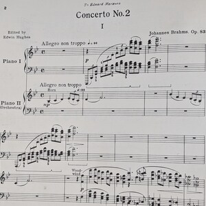 以下が含まれることがあります： ヨハネス・ブラームスのピアノ協奏曲第2番変ロ長調 作品83の第2楽章の楽譜。楽曲は変ロ長調で書かれており、4/4拍子です。楽譜の最初のページには、「協奏曲第2番」というタイトルと作曲家の名前であるヨハネス・ブラームスが書かれています。楽譜はピアノとオーケストラ用で、ピアノのパートが左側に、オーケストラのパートが右側に書かれています。楽譜は伝統的な記譜法で書かれており、音符、記号、拍子記号などが使われています。
