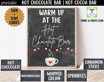 May include: A printable chalkboard-style sign with the text WARM UP AT THE Hot Chocolate Bar, featuring a white mug with a red heart and a row of red, white, and gray dots. Includes matching tent cards labeled Hot Chocolate, Marshmallows, Whipped Cream, Sprinkles, and Cinnamon Sticks.