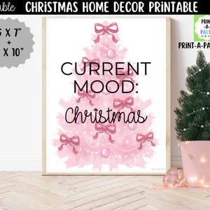 May include: A printable wall art sign featuring a pink watercolor Christmas tree decorated with pink bows and ornaments. The text reads CURRENT MOOD: Christmas. The sign is available in 5 x 7 inch and 8 x 10 inch sizes. A small green tree in a pink pot sits nearby.