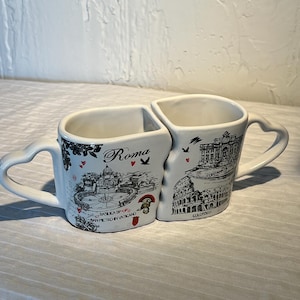 May include: A set of three ceramic mugs with a speckled, matte finish. The mugs are in shades of cream, light gray, and dark gray. Each mug has a simple, minimalist design, perfect for coffee or tea.