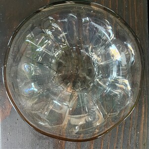 May include: A clear glass bowl with a textured, rippled surface. The bowl is round and has a slightly flared rim.