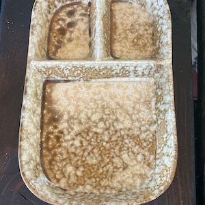 May include: A ceramic serving dish with three sections. The dish is brown and white with a speckled glaze.