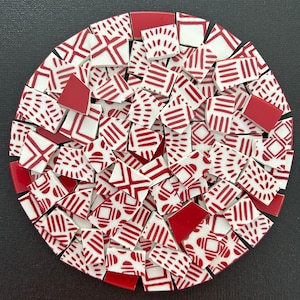 May include: A collection of red and white ceramic tiles with geometric patterns. The tiles are arranged in a circular pattern.